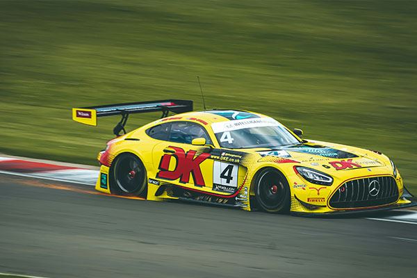 GT3 cars battling in the British GT Championship, watched from the paddock