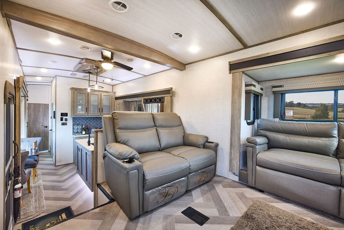 The Heritage Glen's front lounge: reclining sofas either side, with the kitchen and dining area behind